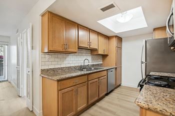 A kitchen with wooden cabinets and a granite countertop.